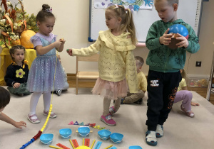 dzieci chodzą wokół urodzinowego słoneczka