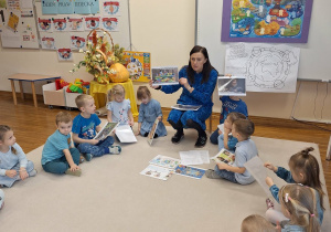 dzieci siedza w kole i słuchaja pani