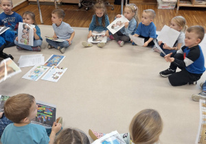 dzieci trzymaja w dłoniach karty z prawami dziecka