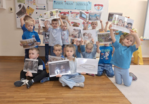 dzieci pokazuja karty z prawami dziecka