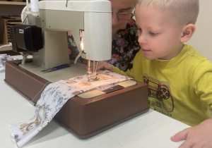 chłopiec szyje na maszynie