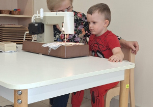 chłopiec szyje na maszynie