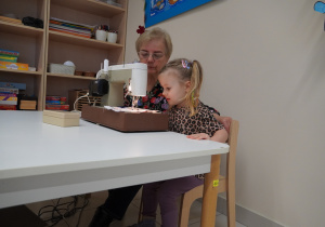 dziewczynka szyje maszyną do szycia