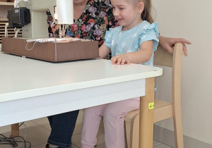 dziewczynka szyje na maszynie