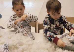 Dziewczynka i chłopiec wypychają poduszki