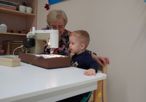 Wiktor szyje maszyną do szycia