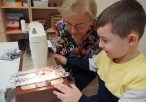 chłopiec szyje na maszynie