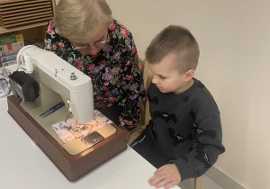 chłopiec szyje na maszynie