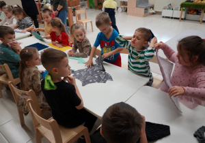 dzieci dotykają różnych tkanin