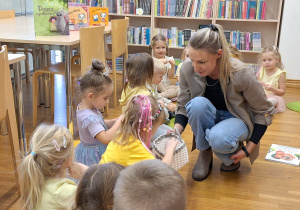 pani rozdaje dzieciom karteczki do zabawy