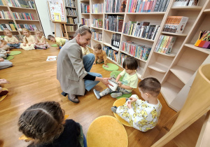 pani rozdaje dzieciom karteczki do zabawy