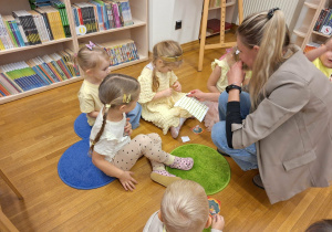 pani rozdaje dzieciom naklejki