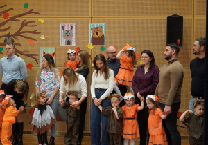 rodzice z dziećmi stoją na scenie