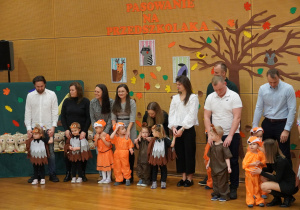 rodzice ze swoimi dziećmi stoją na scenie