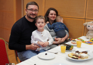 chłopcy siedzą na kolanach rodziców