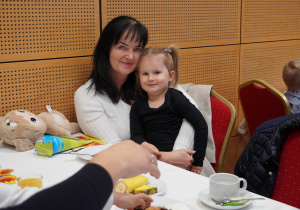 dziewczynka siedzi na kolanach babci