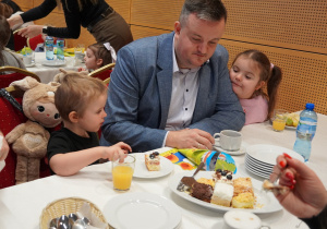 dziewczynki siedzą z tatą przy stole