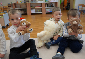 chłopcy pokazują swoje misie