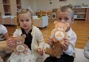 dzieci pokazują papierowe misie