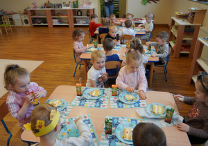 dzieci jedzą tort i piją soki