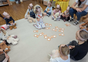 dziewczynka podświetla latarką kartę z misiem