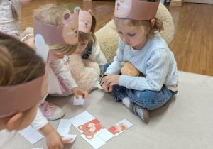 dzieci układają puzzle z misiem