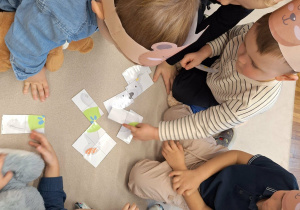 dzieci układają puzzle z misiem