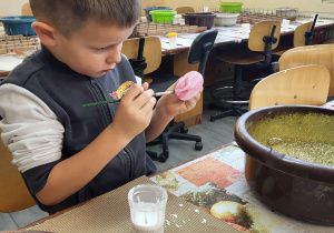 chłopiec maluje bombkę