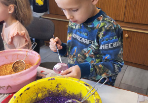 chłopiec maluje bombkę