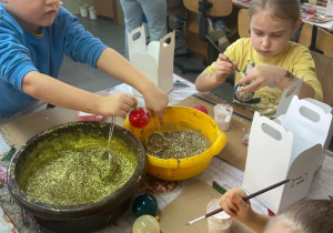 dzieci ozdabiają brokatem swoje bombki