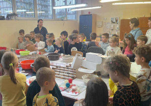 przedszkolaki stoją wokół stolu