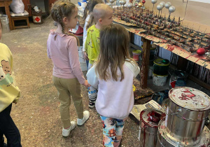 dzieci zwiedzają fabrykę powstawania i dekorowania bombek