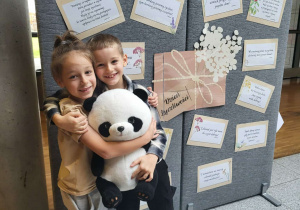 chłopcy pozują na tle gazetki na Dzień życzliwości