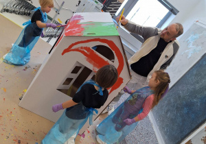 dzieci malują farbami domek