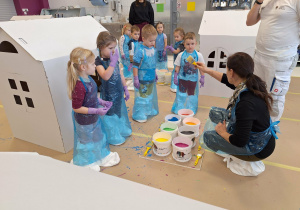 dzieci malują farbami domek