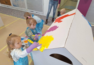 dzieci malują farbami domek