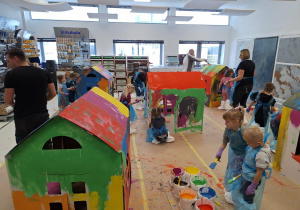 dzieci malują farbami domek