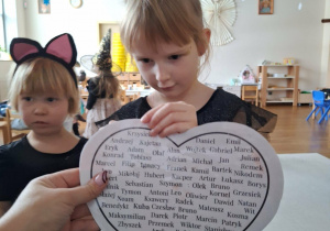 dziewczynka przekuwa serce z imionami