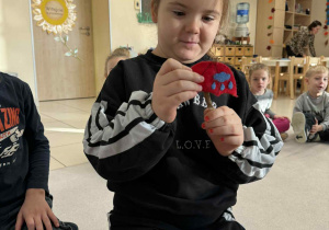 dziewczynka trzyma w ręku filcowy parasol, pokazujący deszczową pogodę