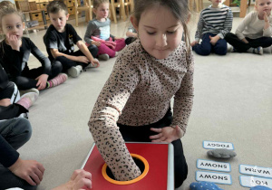 dziewczynka sięga do czerwonego pudełka i losuje wybraną chmurę z pogodą