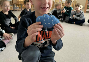 chłopiec trzyma chmurę ze śniegiem