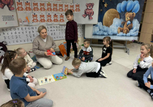 dzieci siedzą w kole i ogladają książeczki anglojęczyne o misiach