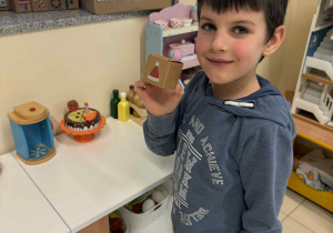 chłopiec trzyma w ręku pudełeczko z numerem