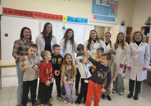 dzieci pozują do zdjęcia z uczenicami z liceum wraz z paniami
