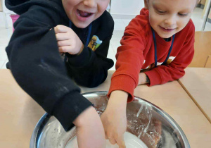 pcy siedzą przy stoliku i dotykają cieszy nienewtonowskiej