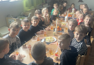 Dzieci przy stole podczas poczęstunku