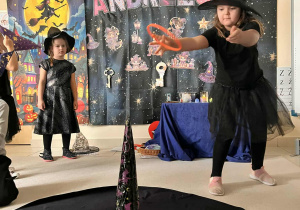 dziewczynka rzuca obręczą i trafia w kapelusz