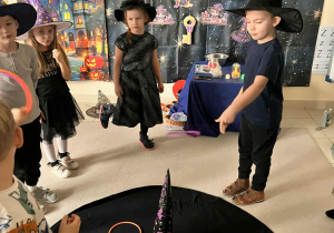 chłopiec rzuca obręczą i trafia w kapelusz