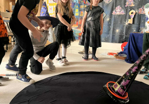 chłopiec rzuca obręczą i trafia w kapelusz