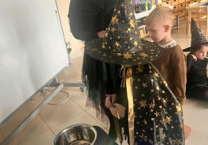 chłopiec wrzuca monetę do miski z wodą